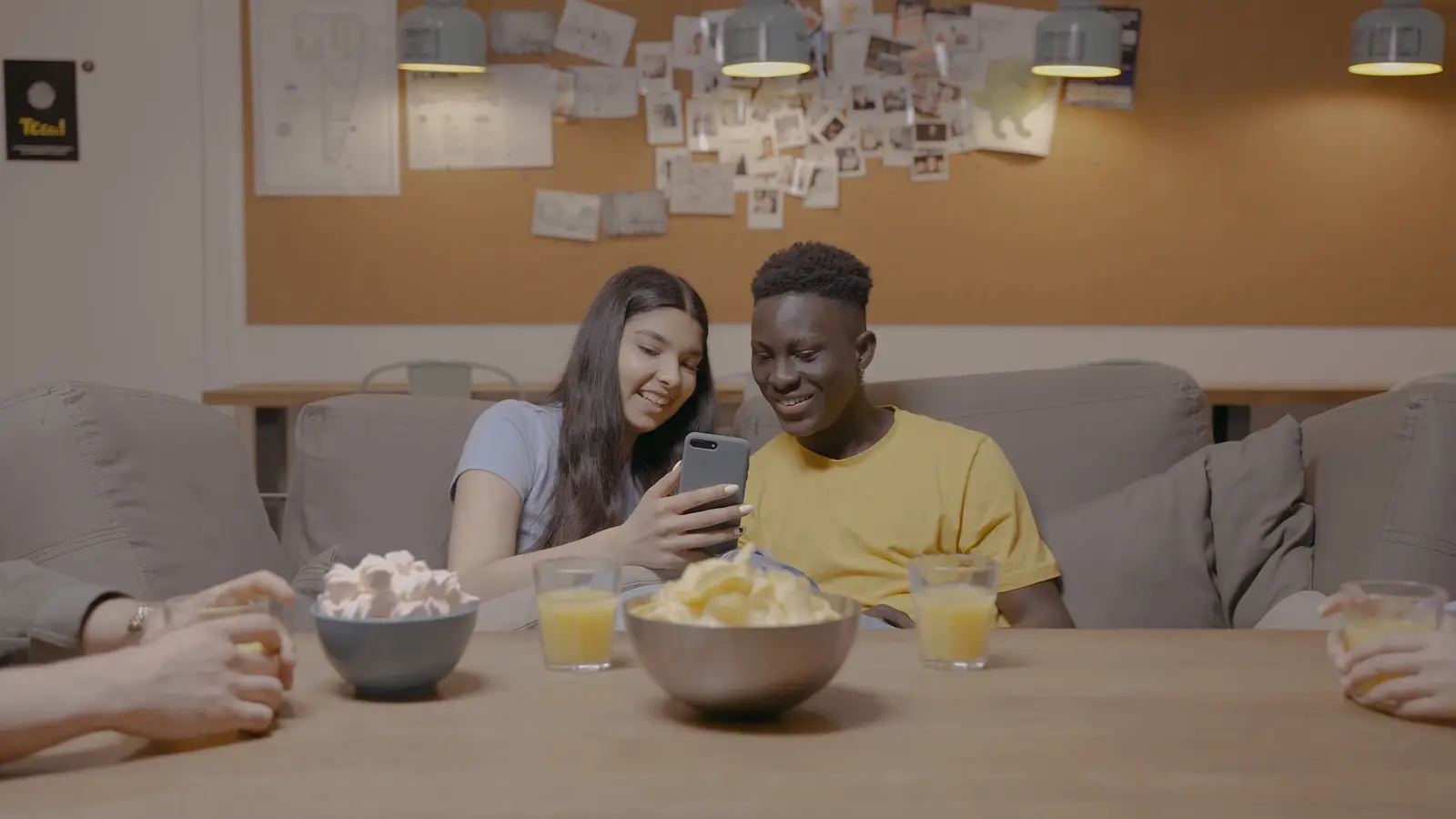 Friends sharing snacks and talking on a sofa