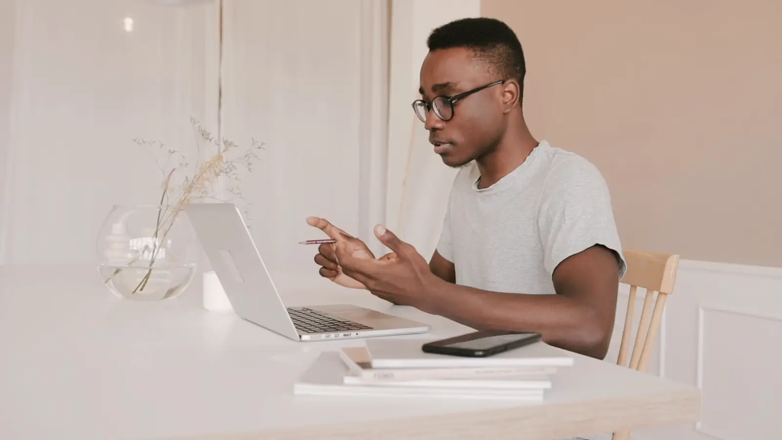 A man in glasses explaining something on a video call