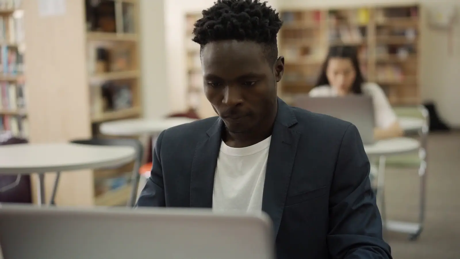 A man working on a laptop in a library