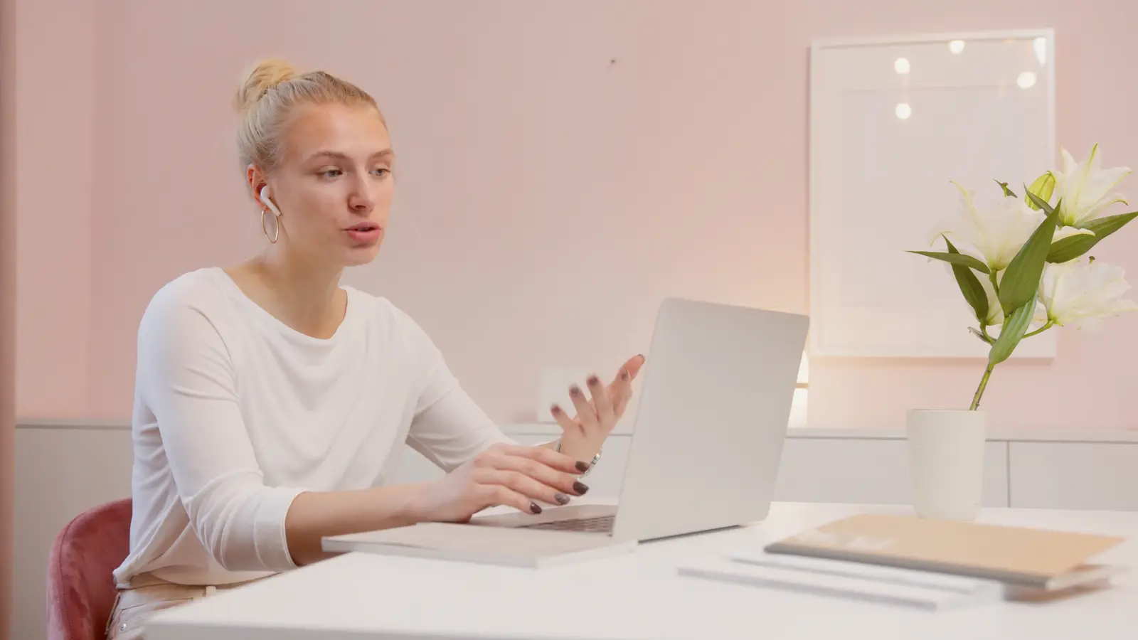 A woman talking and gesturing to her laptop on a video call